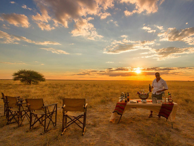 Apéritif au coucher du soleil dans la savane, fauteuils de safari